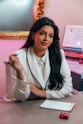 a woman sitting at a desk in front of a mirror