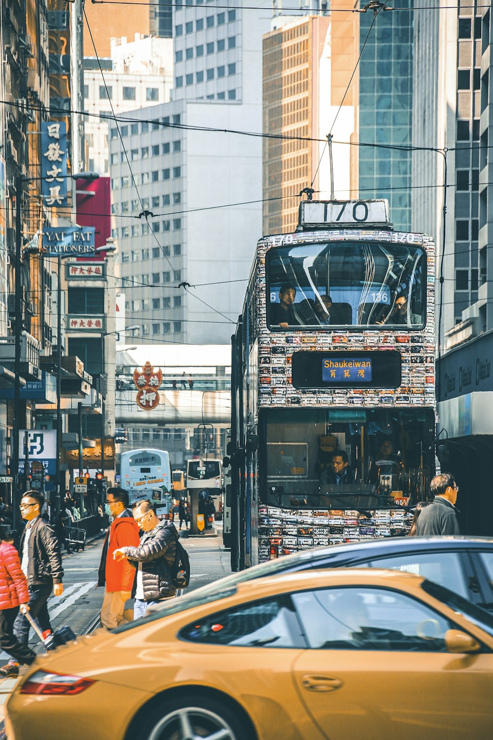 a double decker bus driving down a street next to tall buildings