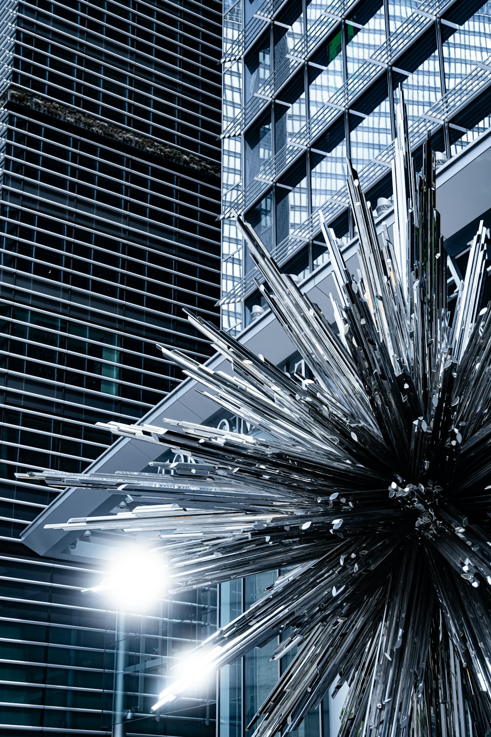 a large metal object in front of a tall building