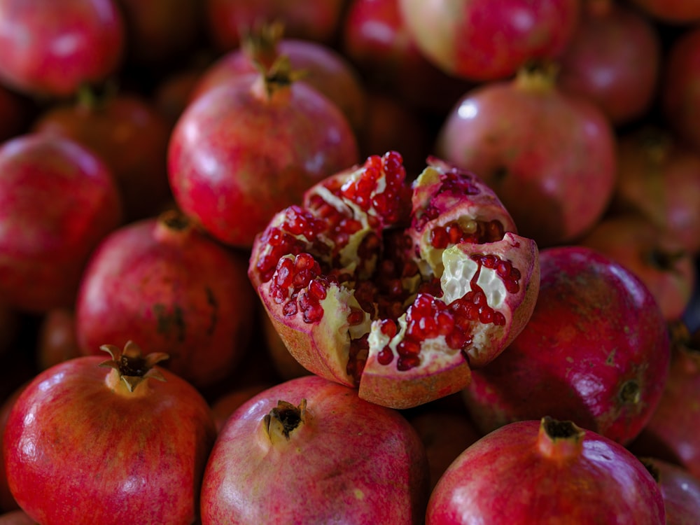 a pile of pomegranates with one cut in half