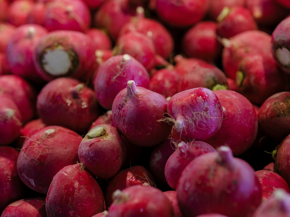 a pile of red radishes sitting on top of each other