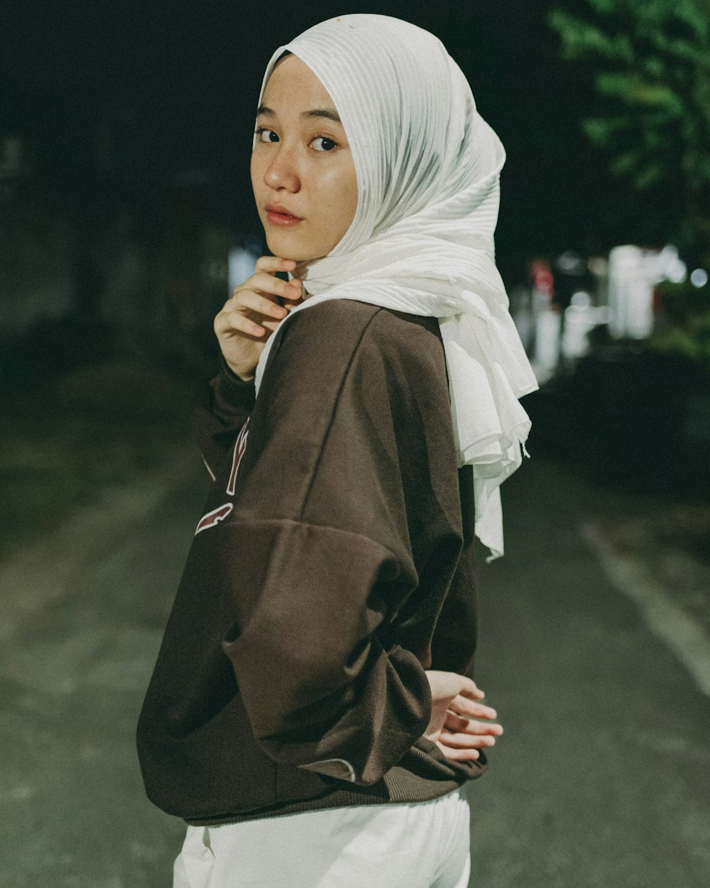 a woman in a hijab standing on a street