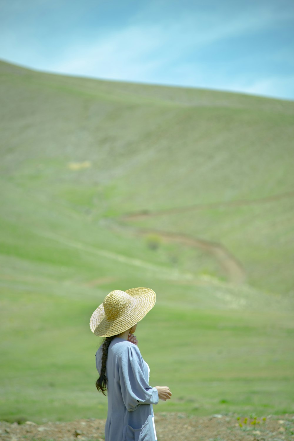 a woman in a straw hat standing in a field