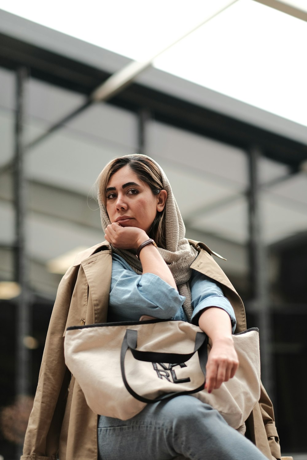 a woman sitting on a bench with her hand on her chin