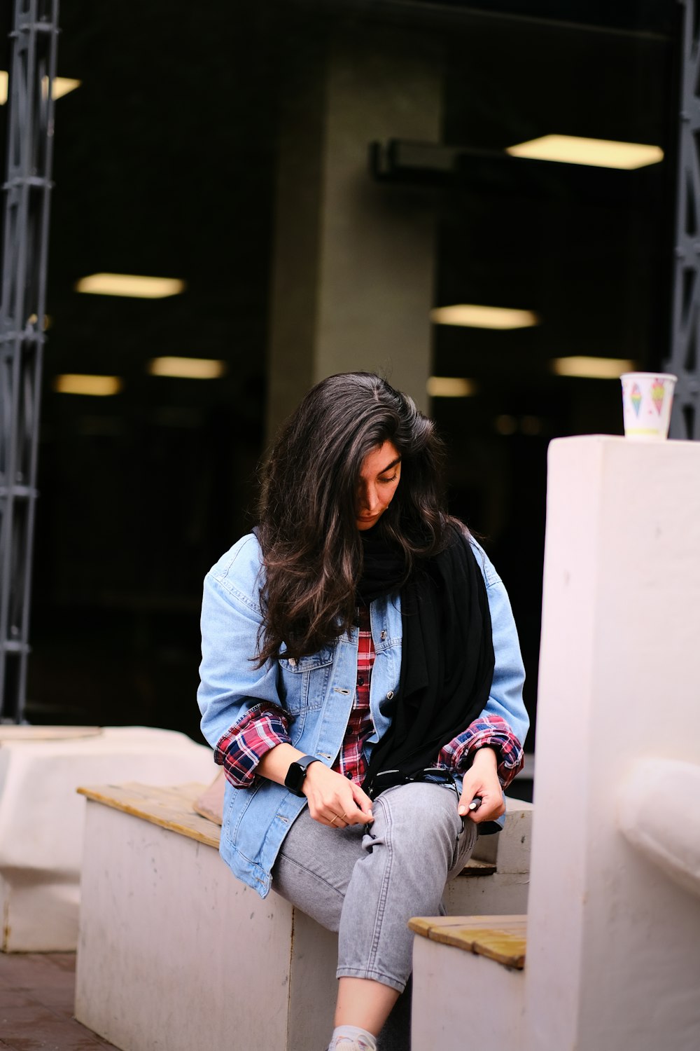 a woman sitting on a bench looking at her cell phone