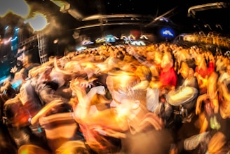 Wide shot of a packed crowd dancing to DJ Kelblizz’s beats at an outdoor night event.