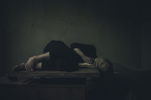 a woman laying on a table in a dark room