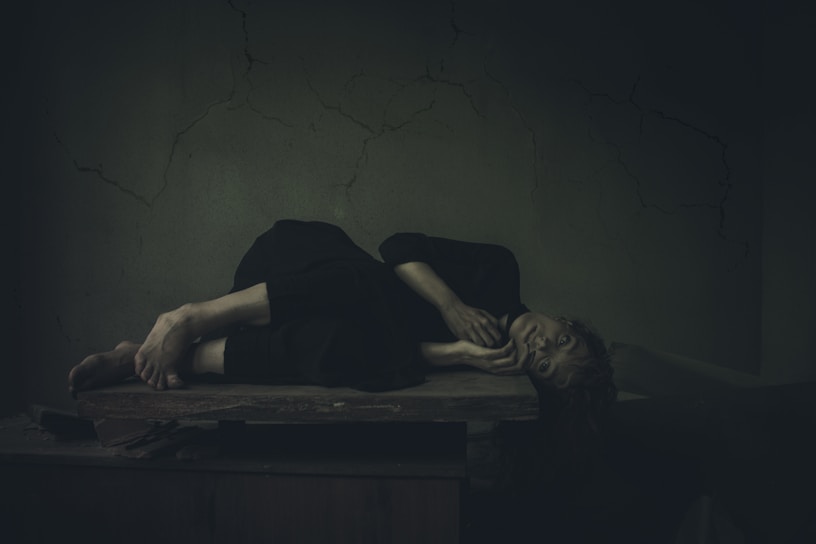 a woman laying on a table in a dark room