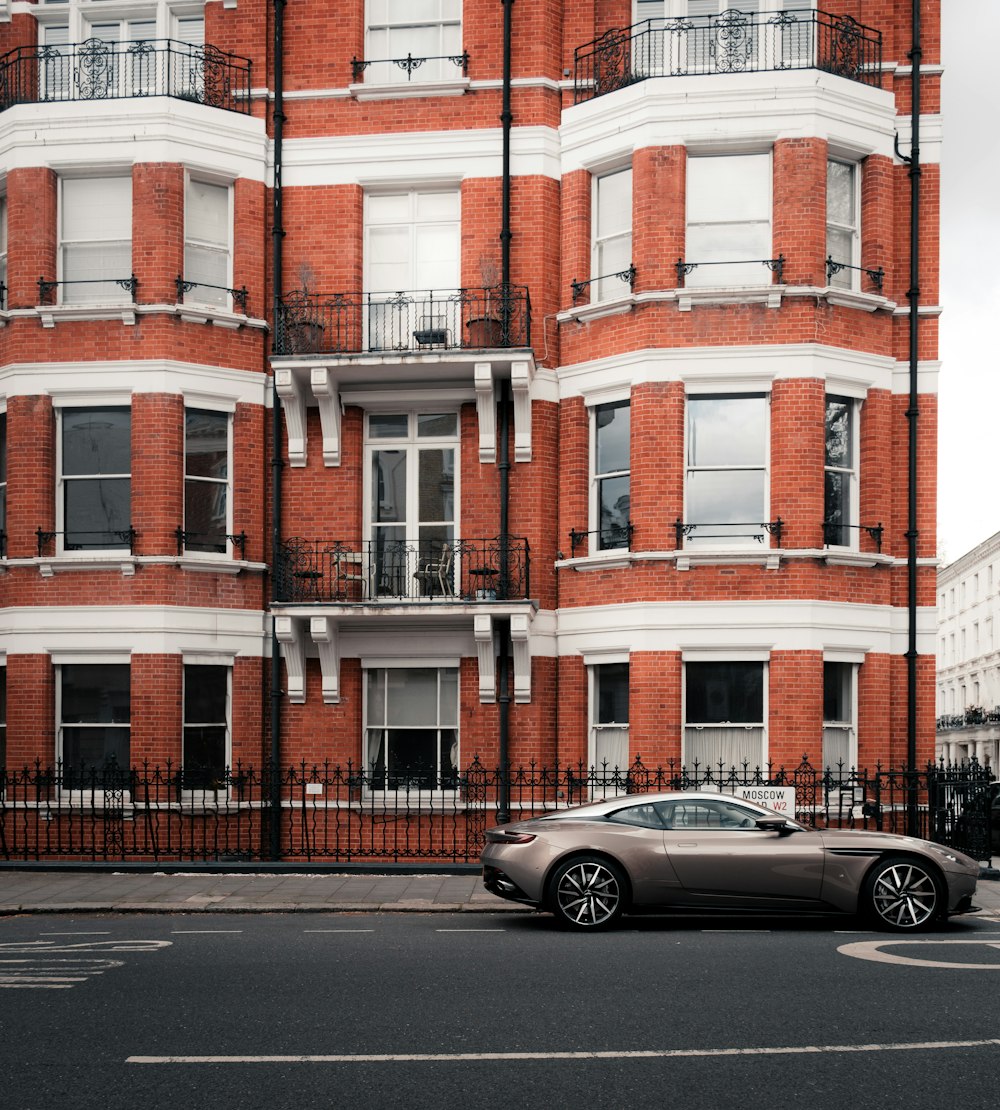 a car parked in front of a tall red brick building