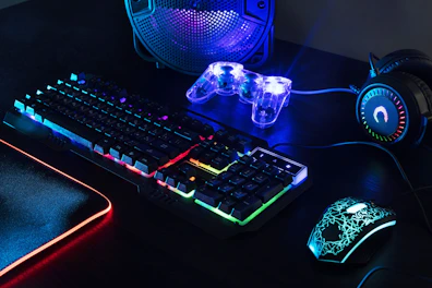 a computer keyboard, mouse, and headphones on a desk