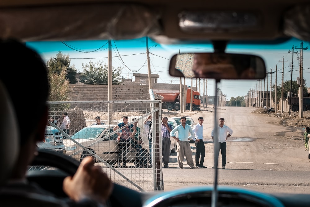 a group of men standing on the side of a road