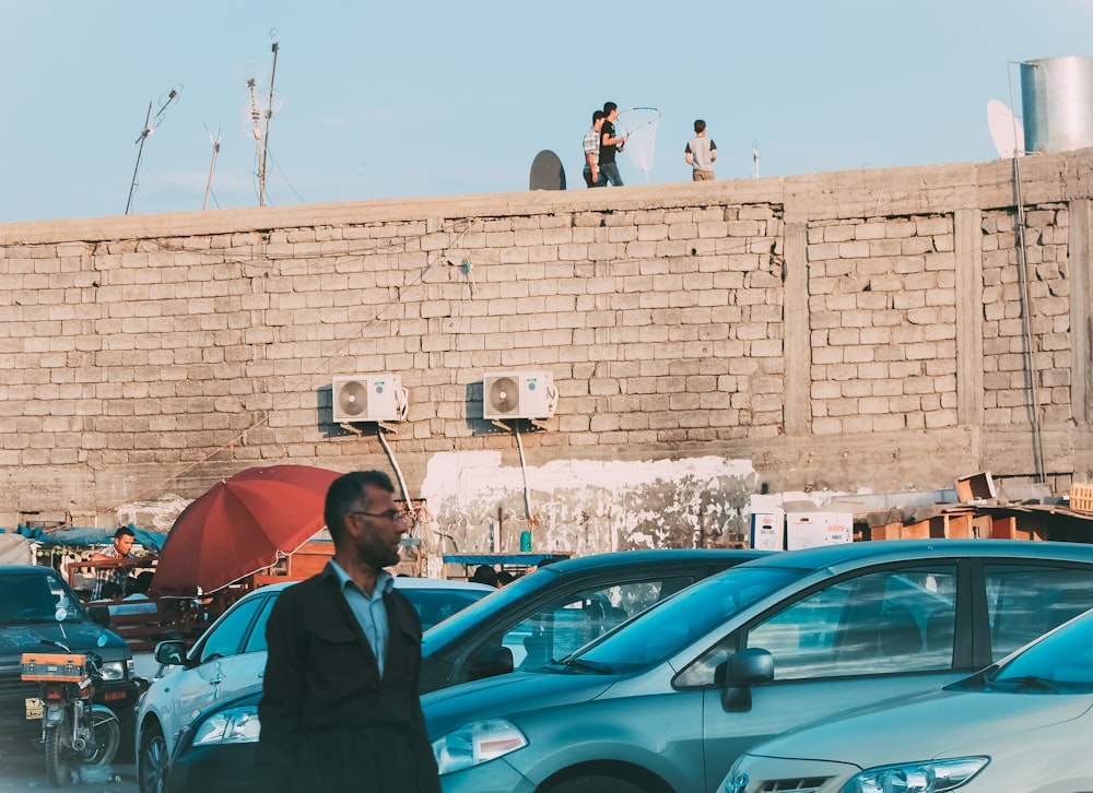 a man in a suit and tie standing in front of parked cars