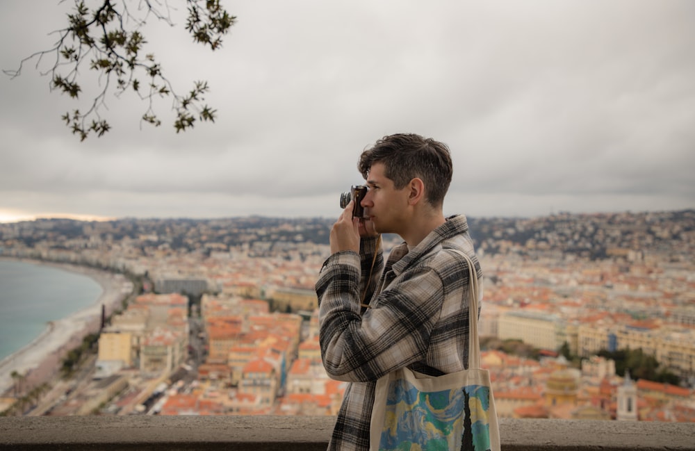 a man taking a picture of a city with a cell phone