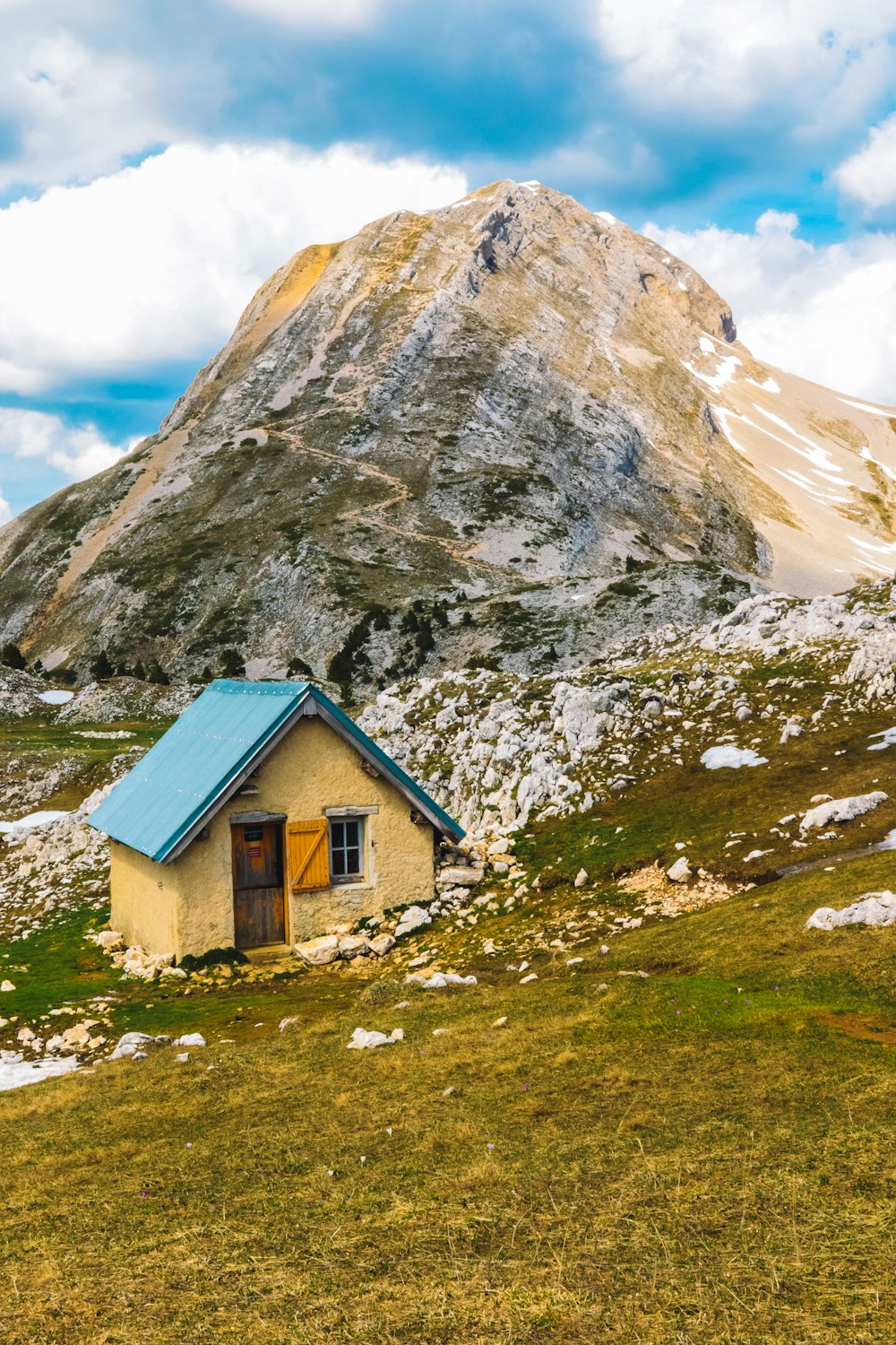 a small house in the middle of a grassy field