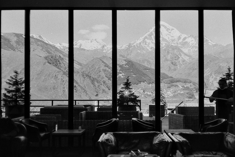 a black and white photo of a person looking out a window