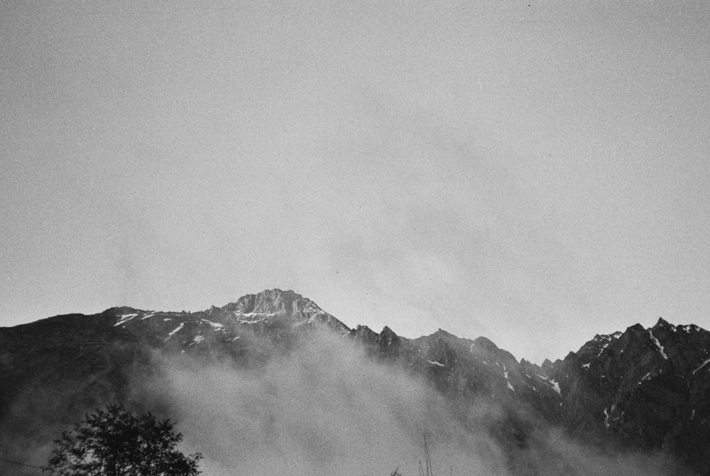 uma foto em preto e branco de uma montanha coberta de neblina