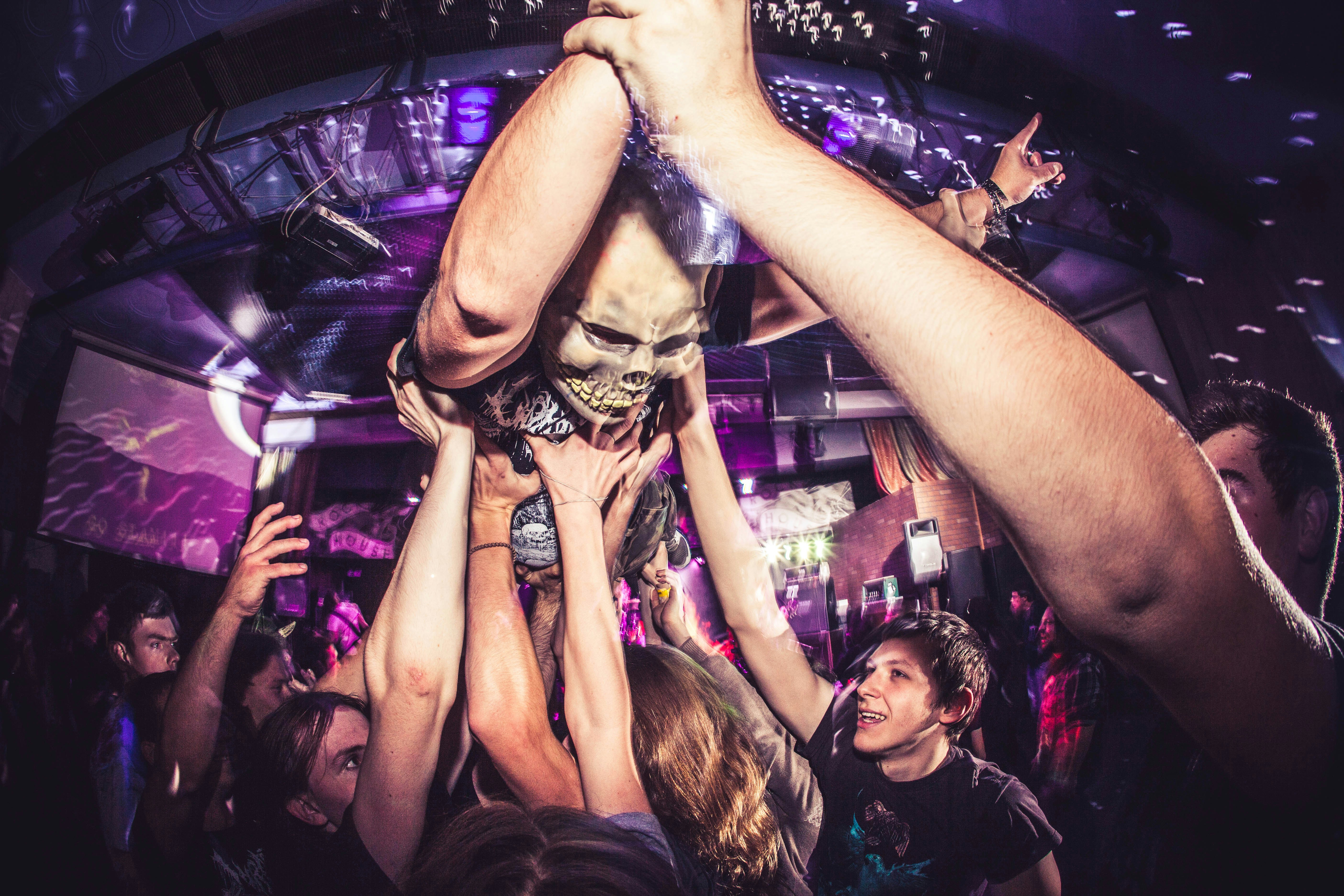 Eine Gruppe von Menschen, die mit den Händen in der Luft umeinander stehen