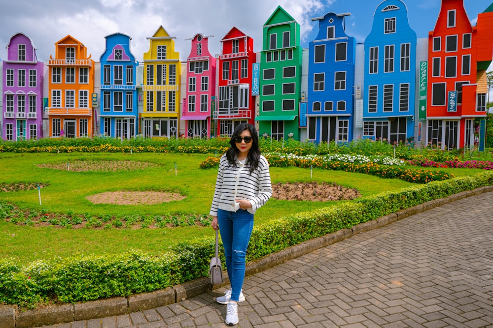 Una donna in piedi di fronte a una fila di case colorate
