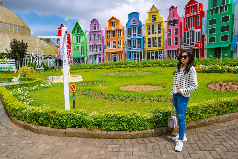 a woman standing in front of a colorful building
