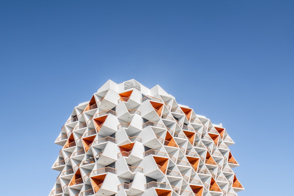 a tall white building with orange triangles on it