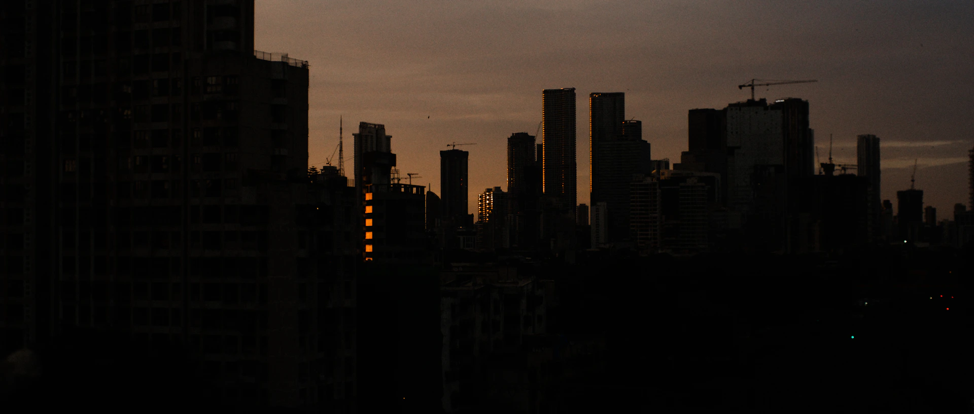 An elegant skyline at dusk featuring cranes and mining machinery, symbolizing JJSR Corporation's impact across India's infrastructure and mining sectors.