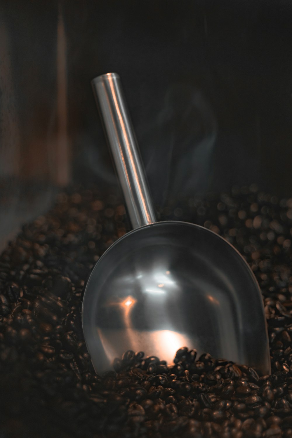 a scoop of coffee sitting on top of a pile of coffee beans