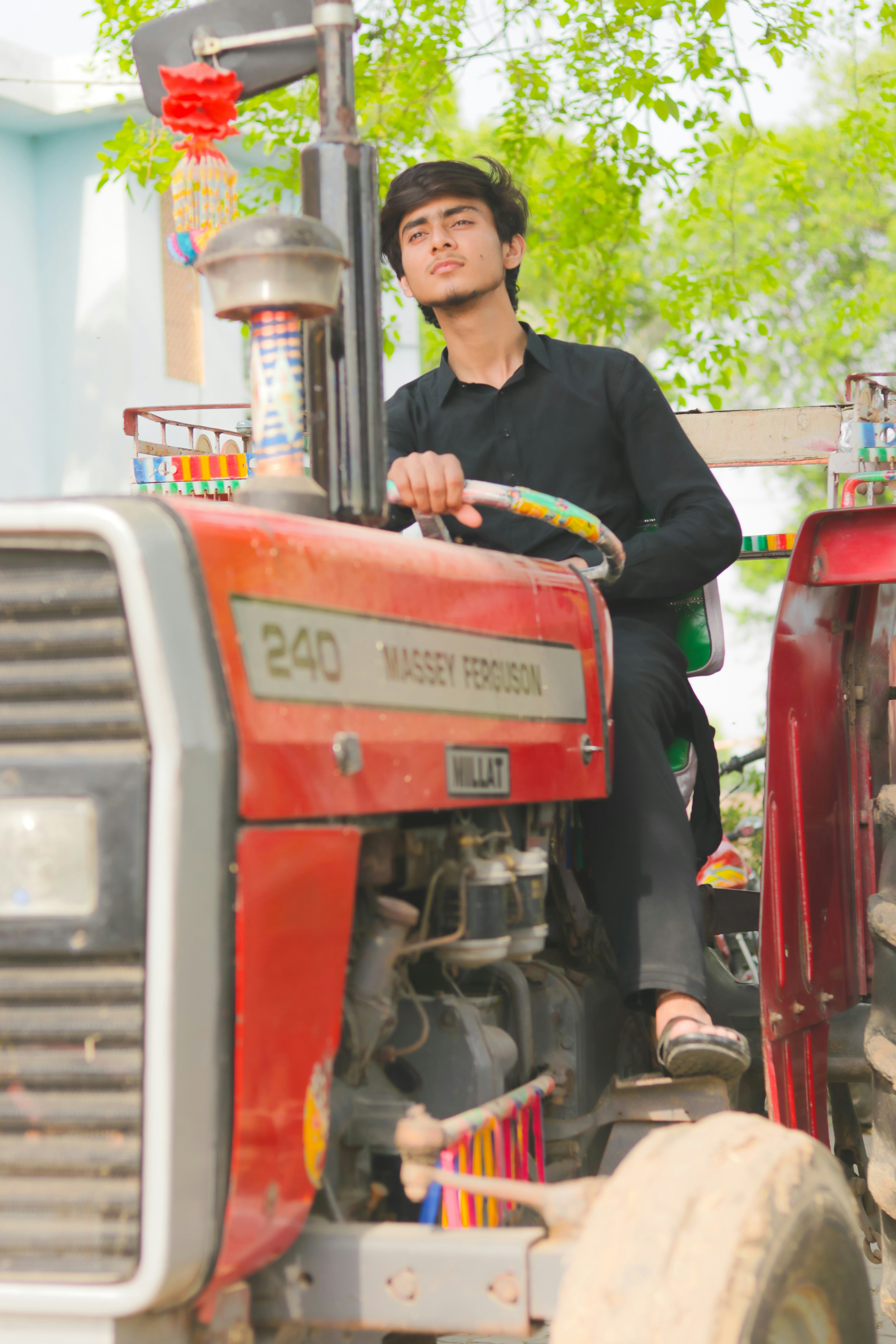 a man riding on the back of a red tractor