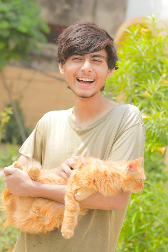Theo Nakamura holding Marmalade, his long-haired ginger cat
