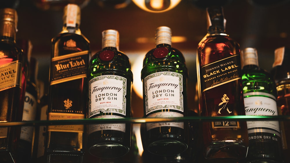 a shelf filled with bottles of different types of liquor