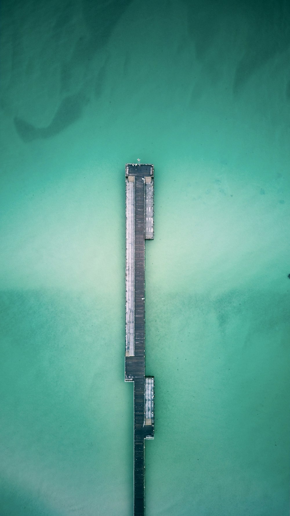 an aerial view of a pier in the water