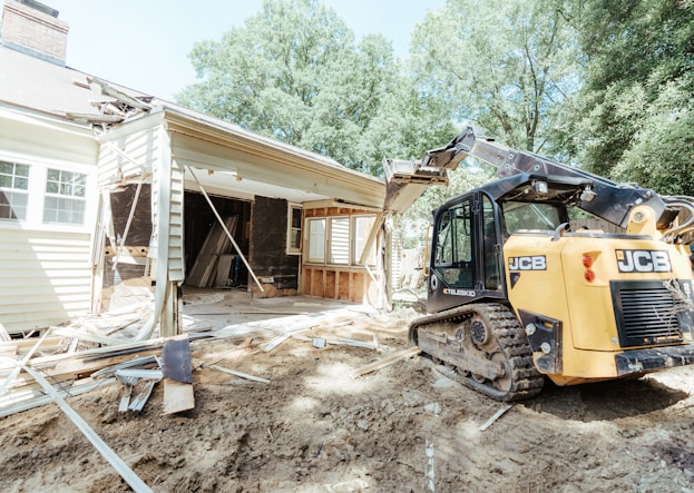 a bulldozer is parked in front of a house