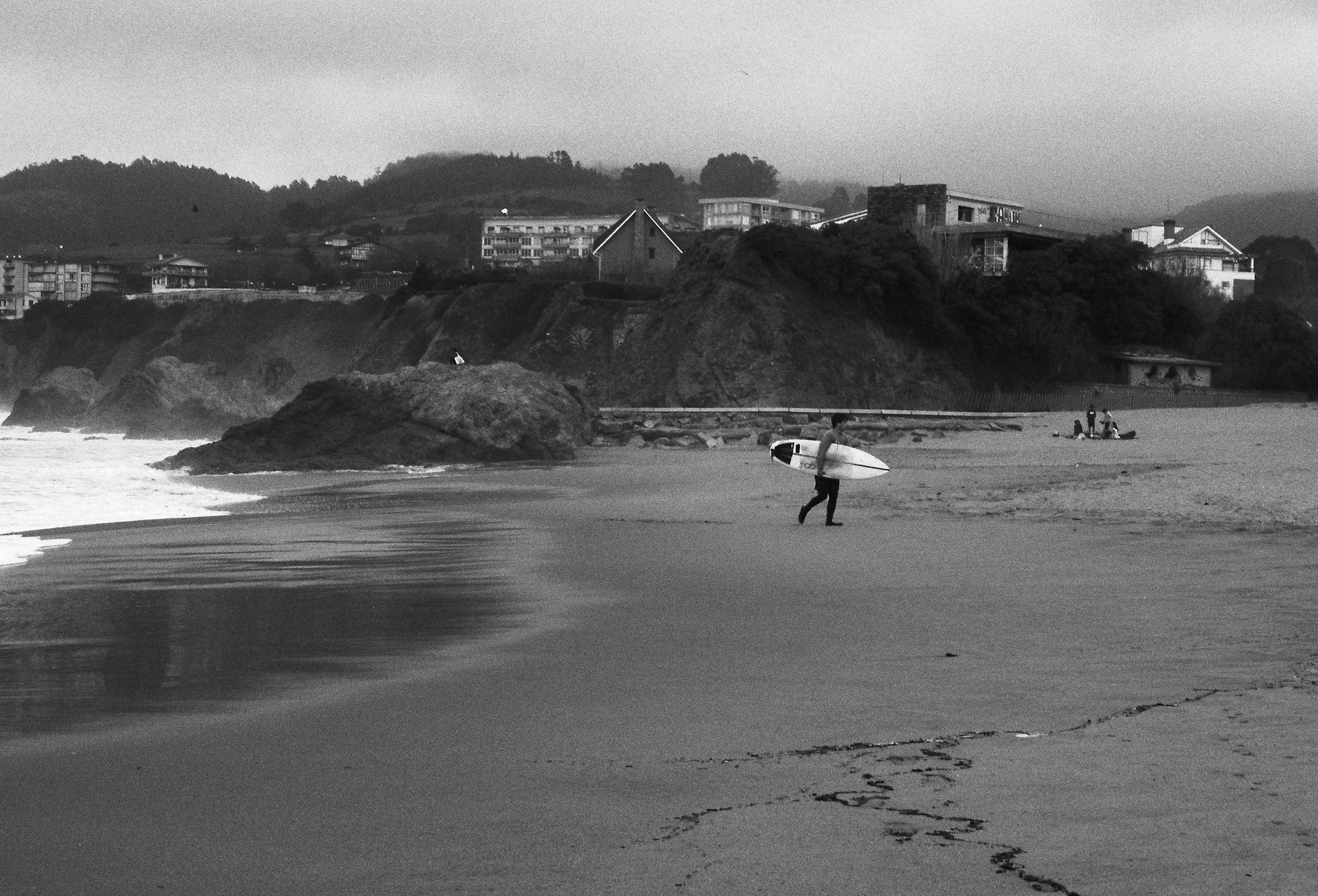 a person walking on a beach with a surfboard
