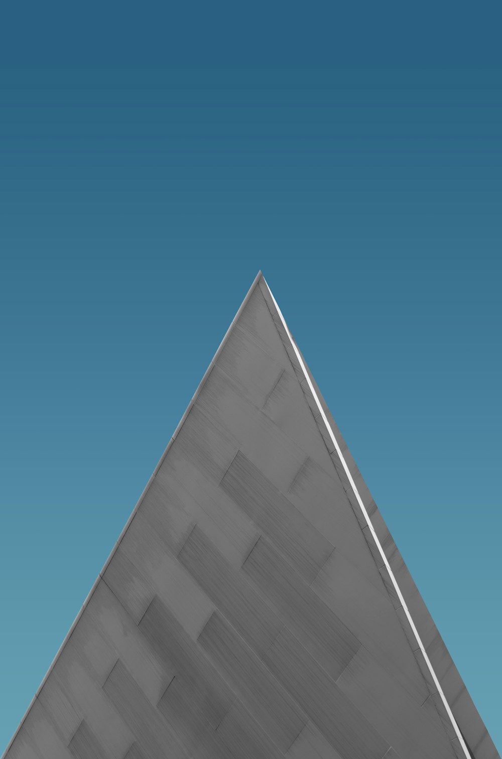 a triangle shaped object with a blue sky in the background