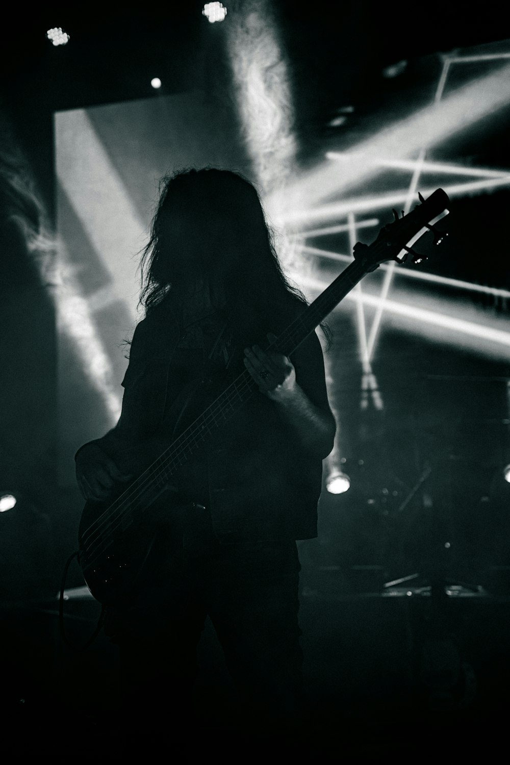 a black and white photo of a person playing a guitar