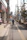 Urban scene showing a parent walking with a stroller equipped with the hammock, children smiling.