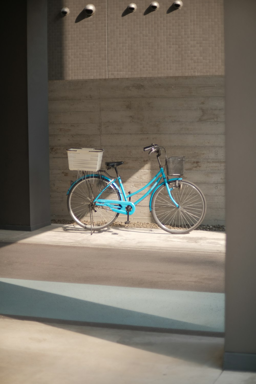 a blue bike parked next to a brick wall