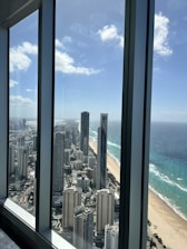 A panoramic view of the Sattva Parel residential towers with the sea visible in the distance under a clear sky.