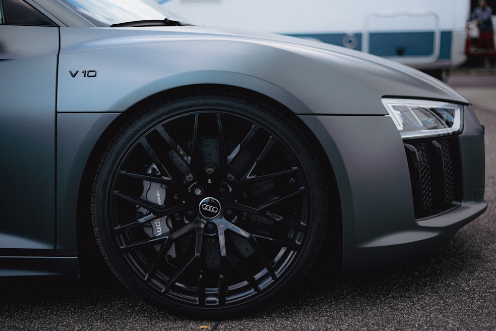 a grey sports car parked in a parking lot