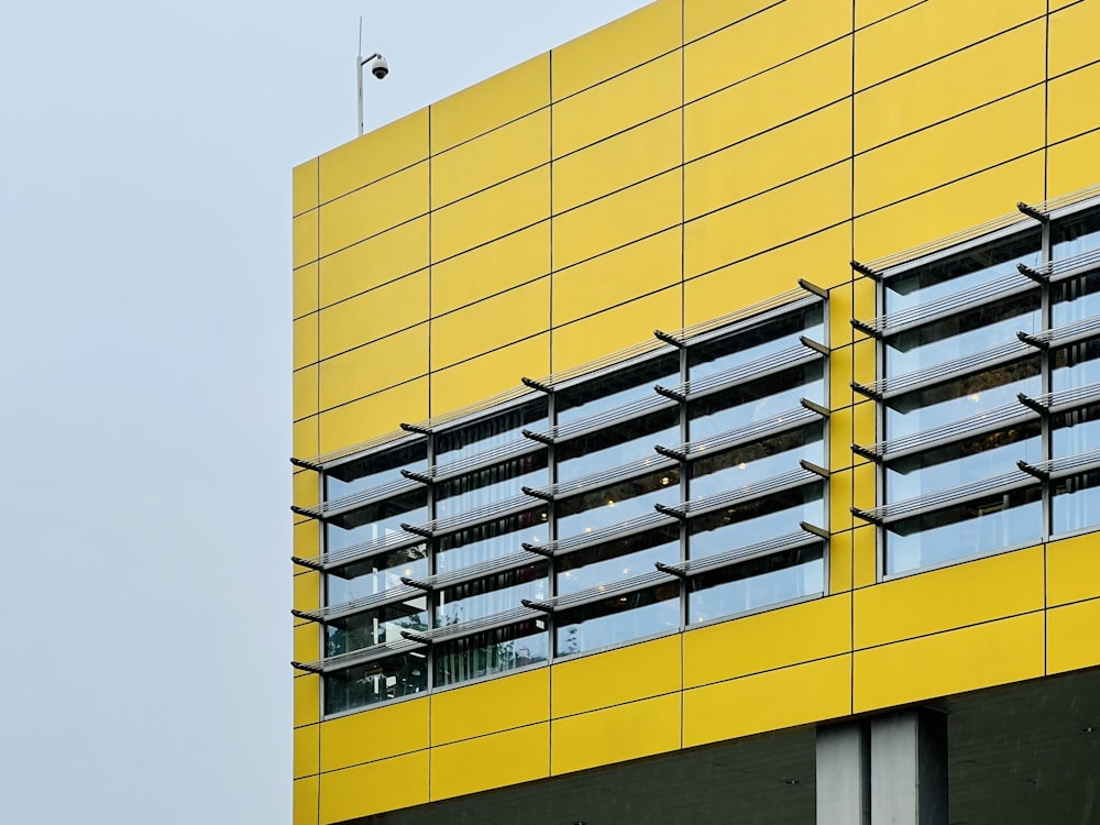 a tall yellow building with windows and balconies