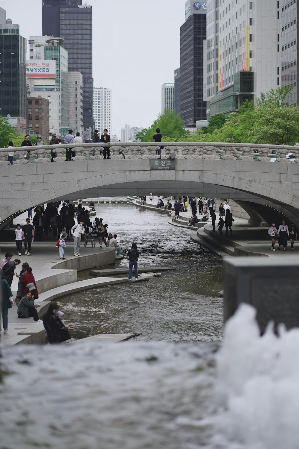 a group of people standing on a bridge over a river