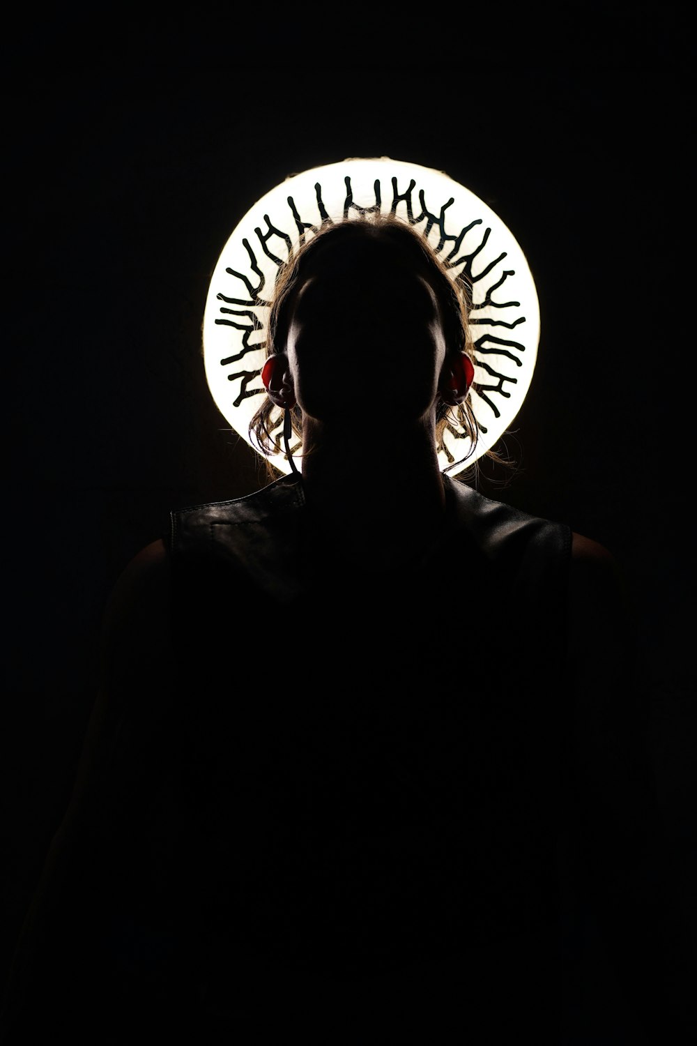 a person standing in a dark room with a circular object on their head