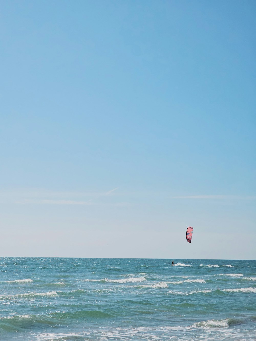 a person para sailing in the ocean on a sunny day