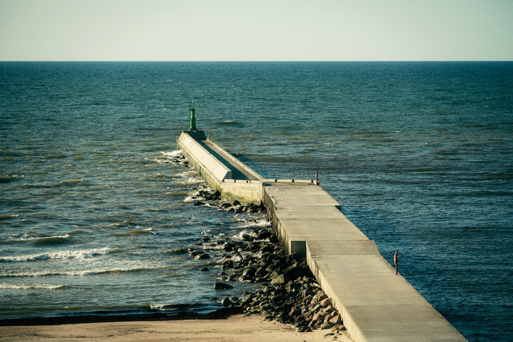 a long concrete wall next to a body of water