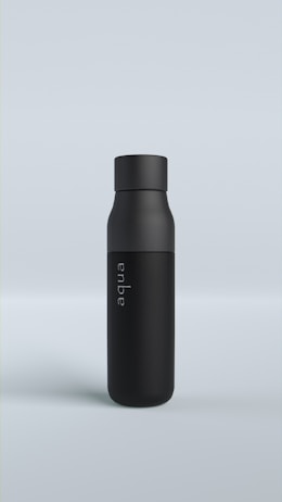 A sleek black bottle standing upright on a light gray background. The bottle has a matte finish and features the word 'aqua' written vertically in a subtle font.