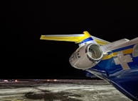 A nighttime exterior shot of an Orvessan jet illuminated by soft runway lights.