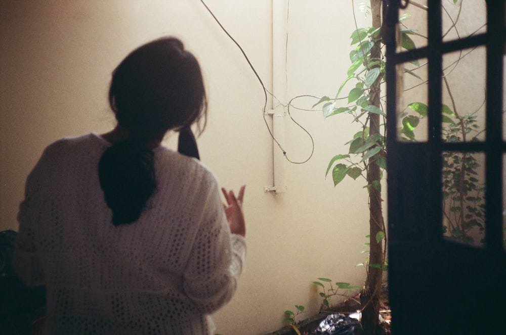 a woman standing in a room talking on a cell phone