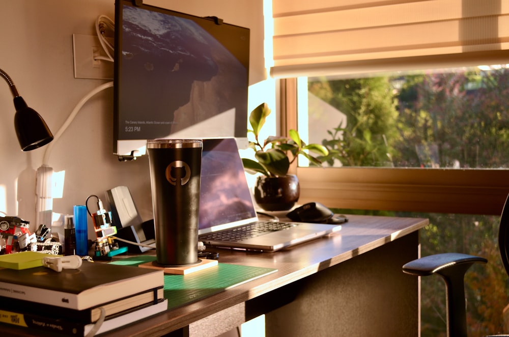 a laptop computer sitting on top of a wooden desk