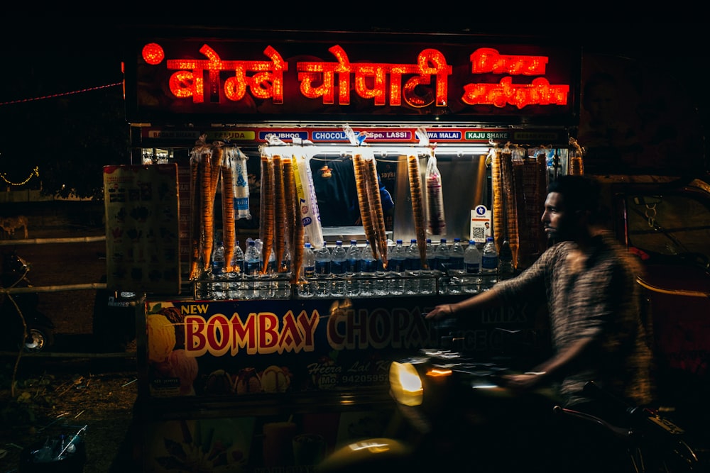 a man riding a motorcycle next to a vending machine