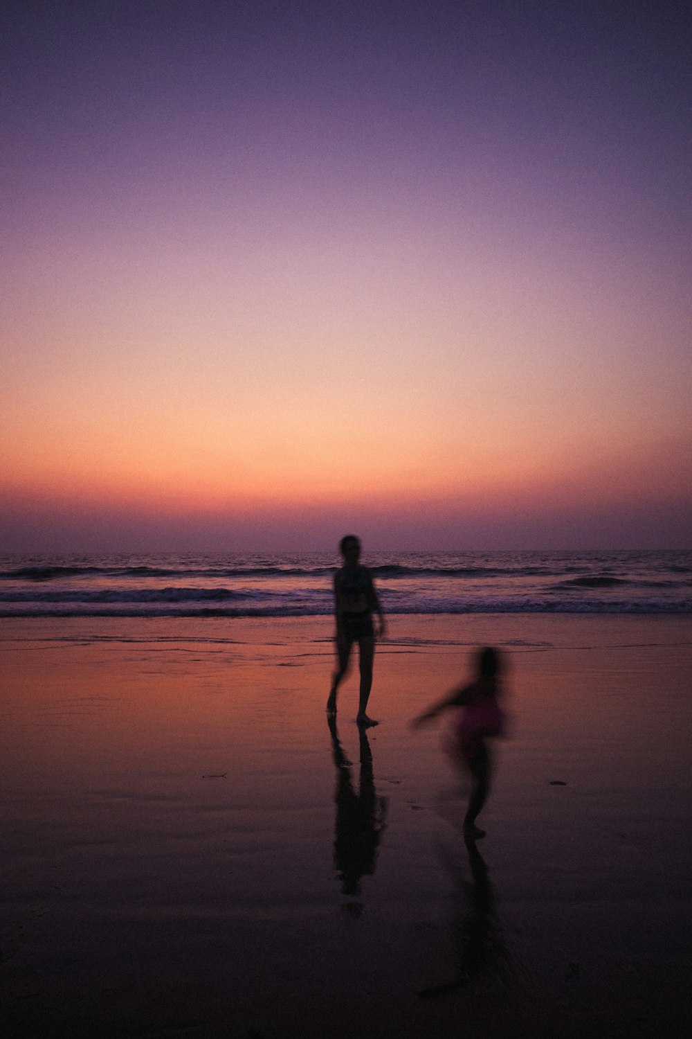 a couple of people standing on top of a beach