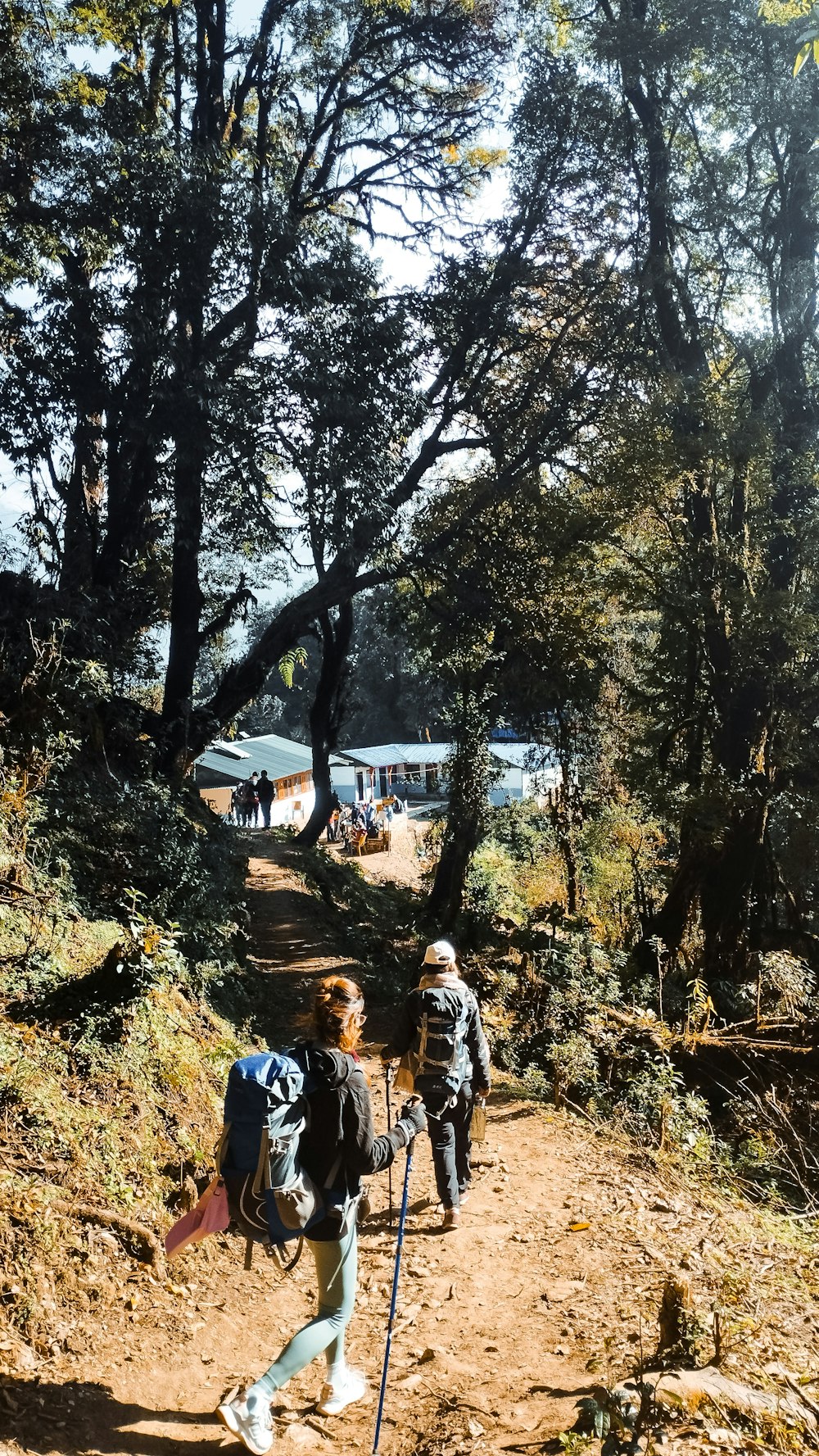 a couple of people walking down a dirt road